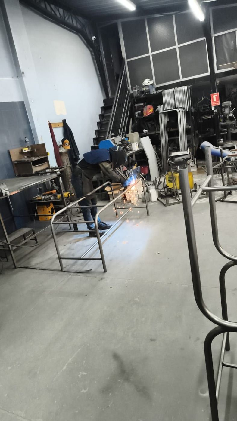 Soldador uniendo la estructura tubular de una camilla